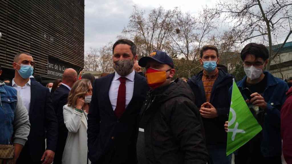 Santiago Abascal (Vox) posa con uno de los manifestantes concentrados a las puertas del Parc de la Ciutadella en Barcelona / EUROPA PRESS