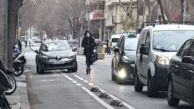 Una mujer en patinete eléctrico circulando entre los coches / @CBinvaders