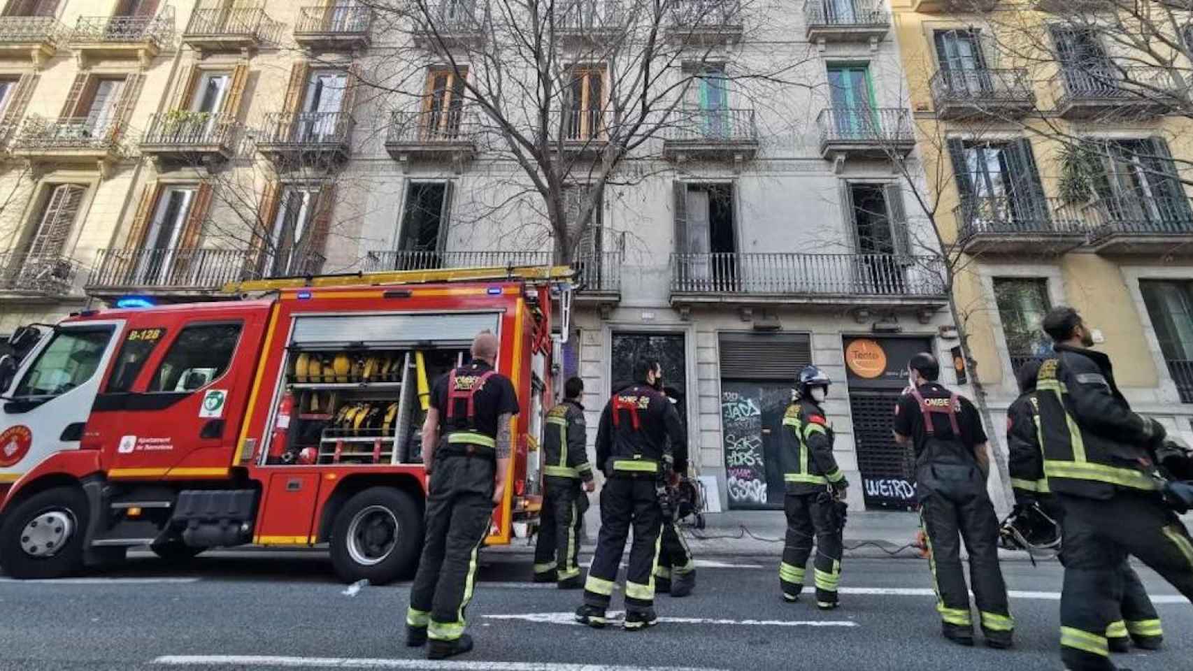 Bomberos trabajan para apagar el fuego en un piso de Pau Claris / LENA PRIETO