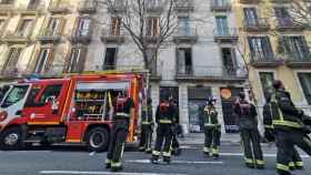 Bomberos trabajan para apagar el fuego en un piso de Pau Claris / LENA PRIETO