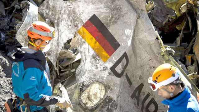 Miembros de los equipos de rescate mientras revisaban restos del fuselaje del avión en el lugar de la catástrofe / EFE