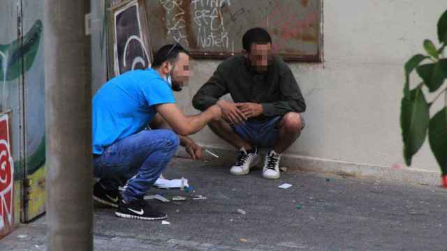 Dos usuarios de la narcosala del Raval (CAS Baluard) consumiendo heroína en el exterior del equipamiento / CEDIDA