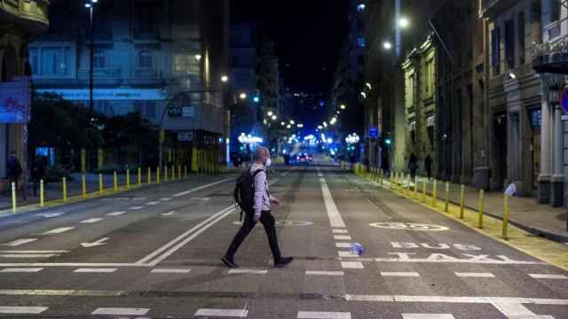 Una persona pasea por la calle durante el toque de queda / EFE