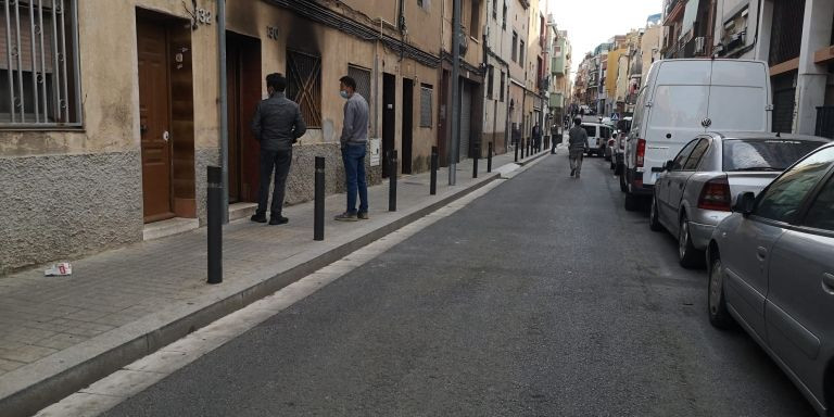 Dos hombres delante de la vivienda que el pasado fin de semana sufrió un incendio / METRÓPOLI ABIERTA