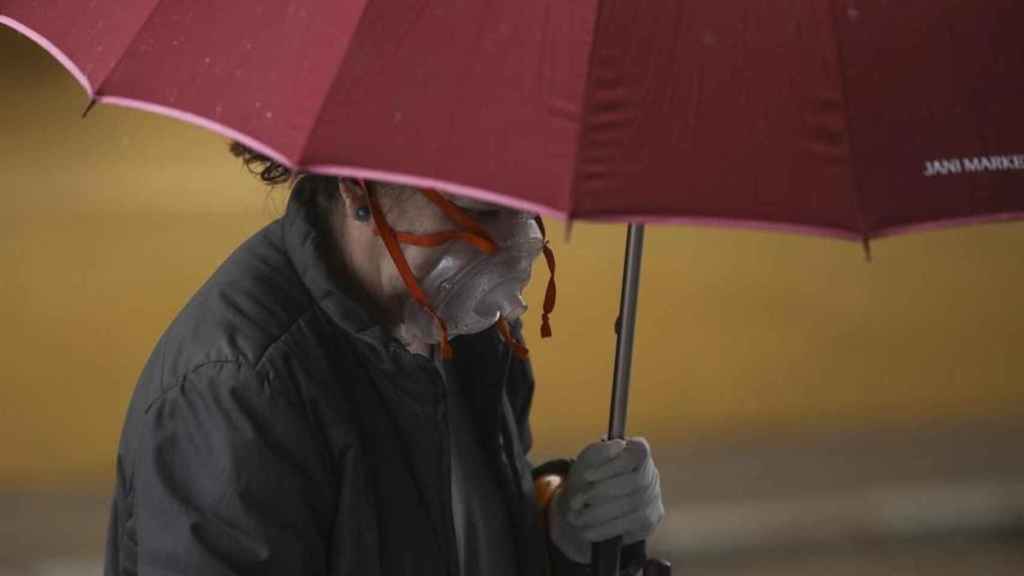 Una mujer con paraguas y mascarilla / EUROPA PRESS