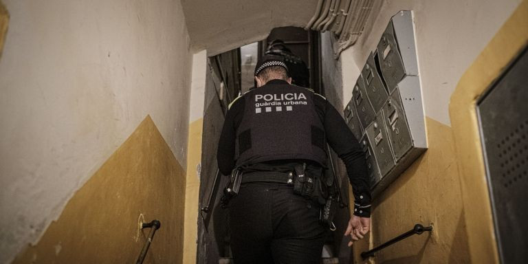 Guardias urbanos suben hasta el piso donde tiene lugar una fiesta en la calle de Escudellers Blancs / PABLO MIRANZO