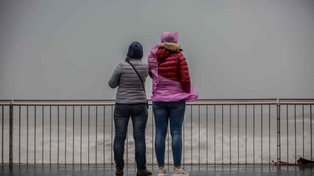 Dos mujeres en el paseo marítimo de Barcelona durante un episodio de chubascos y tormentas / EUROPA PRESS