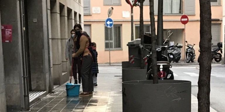 Una vecina limpia la acera de la calle Mare de Déu del Carmel / CEDIDA