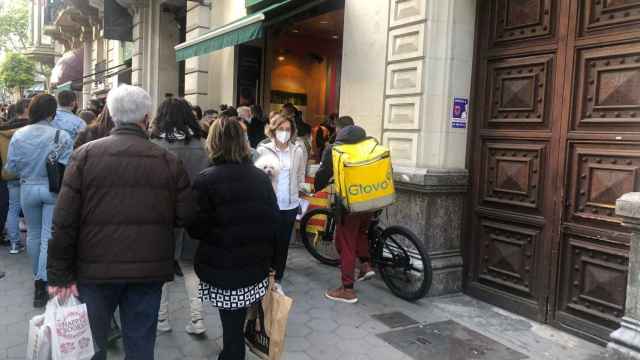 Un repartidor de Glovo ante la Casa del Libro de paseo de Gràcia