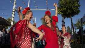 Mujeres bailan sevillanas en la Feria de Abril