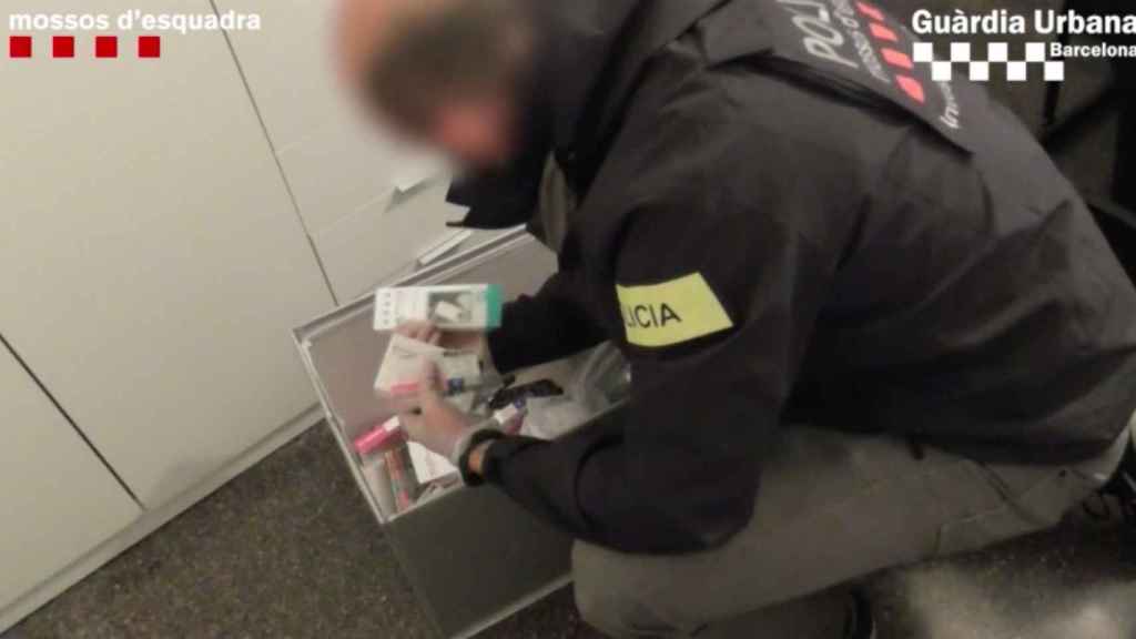 Un mosso inspecciona cajas de medicamentos durante la operación / MOSSOS