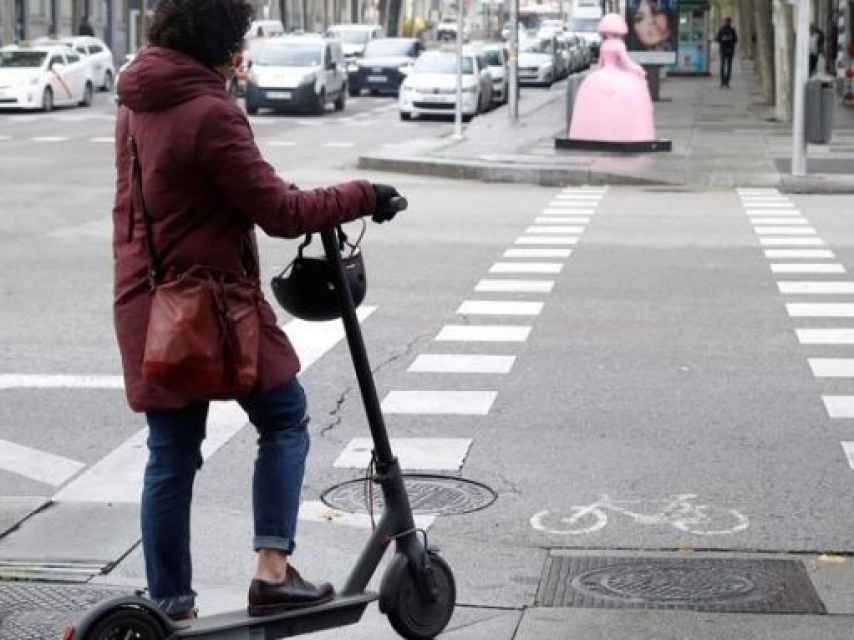 Una usuaria sin casco montada en un patinete eléctrico en Barcelona