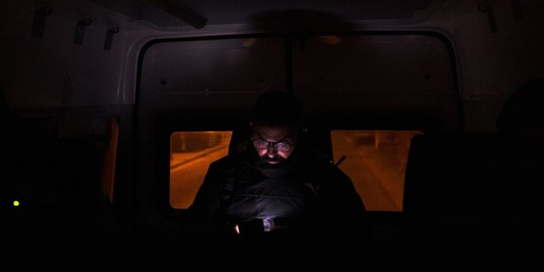 Un guardia urbano consulta su móvil en el interior de la furgoneta / PABLO MIRANZO