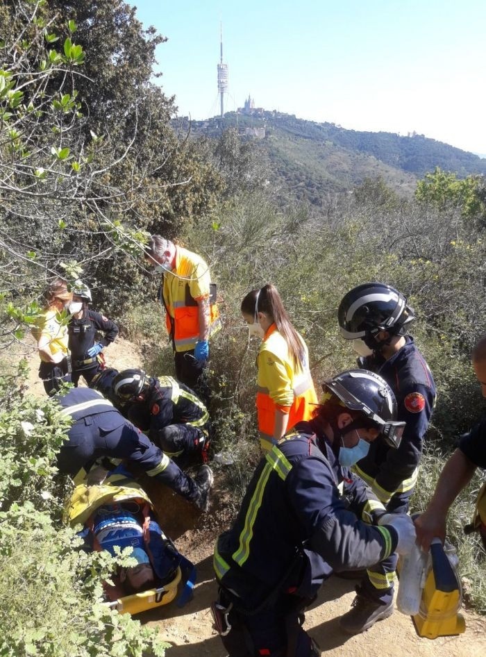 Bomberos y sanitarios trasladan al herido en Collserola / BOMBERS DE BARCELONA