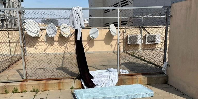 Colchón y ropa de uno de los okupas cuando dormía en la terraza / CEDIDA