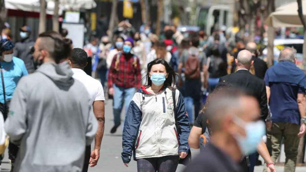 Personas con mascarilla pasean por la calle / EUROPA PRESS