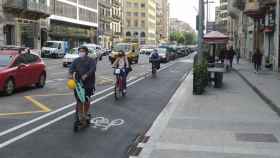 Usuarios en patinete y bicicleta en el carril bici de Aragó, a la altura del paseo de Gràcia / METRÓPOLI - JORDI SUBIRANA