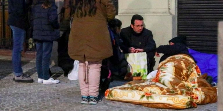 El padre Felipe Simón atiende a un sintecho junto a voluntarios del proyecto de San Alberto de Hurtado / AV