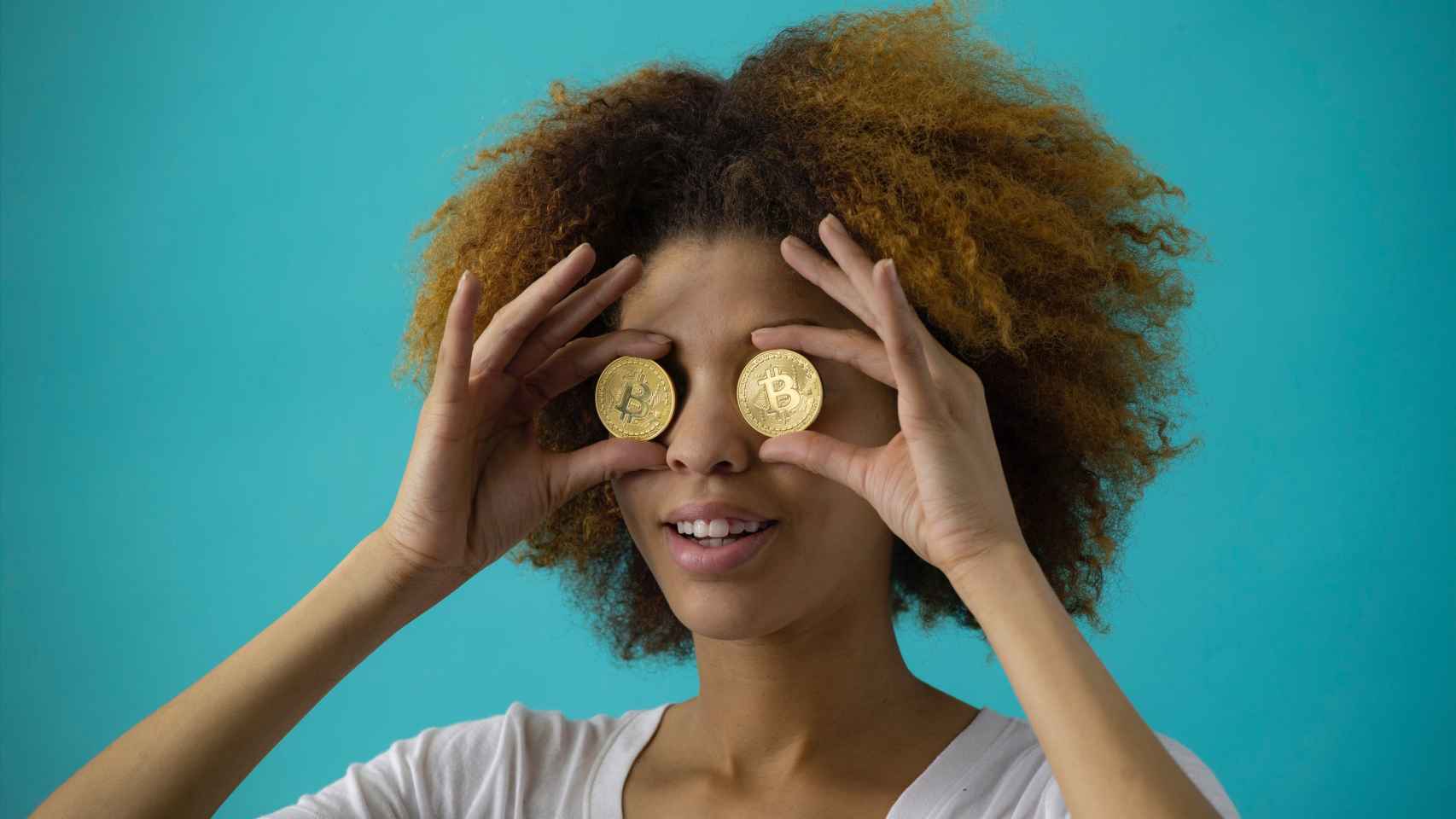 Mujer con dos bitcoins a modo de gafas / PEXELS