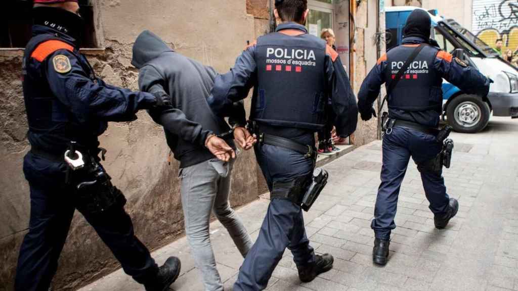 Los Mossos d'Esquadra custodian a un detenido en una imagen de archivo / EFE