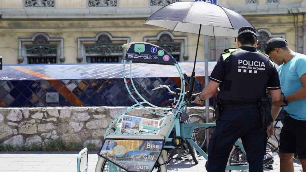 Ofensiva municipal: un agente de la Guardia Urbana inspecciona un bicitaxi / AYUNTAMIENTO DE BARCELONA