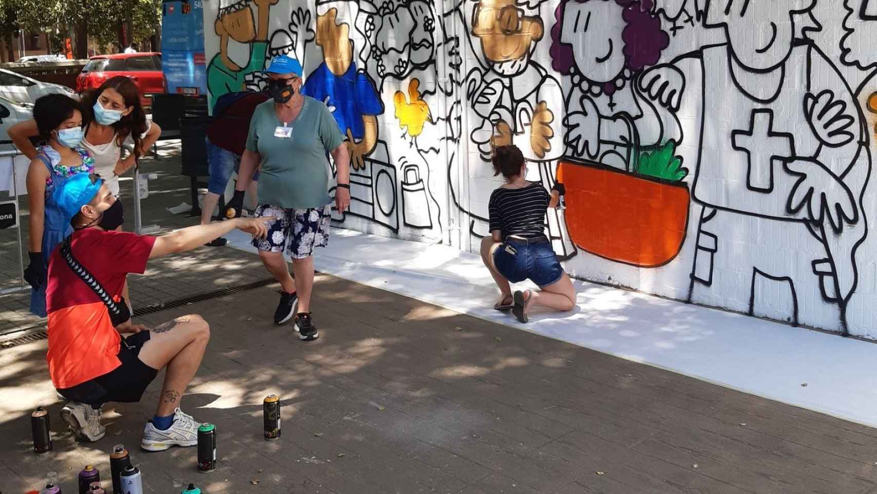 Dos personas pintan el mural en homenaje a las víctimas de coronavirus en el Besòs i Maresme / ASSOCIACIÓN VECINOS MARESME