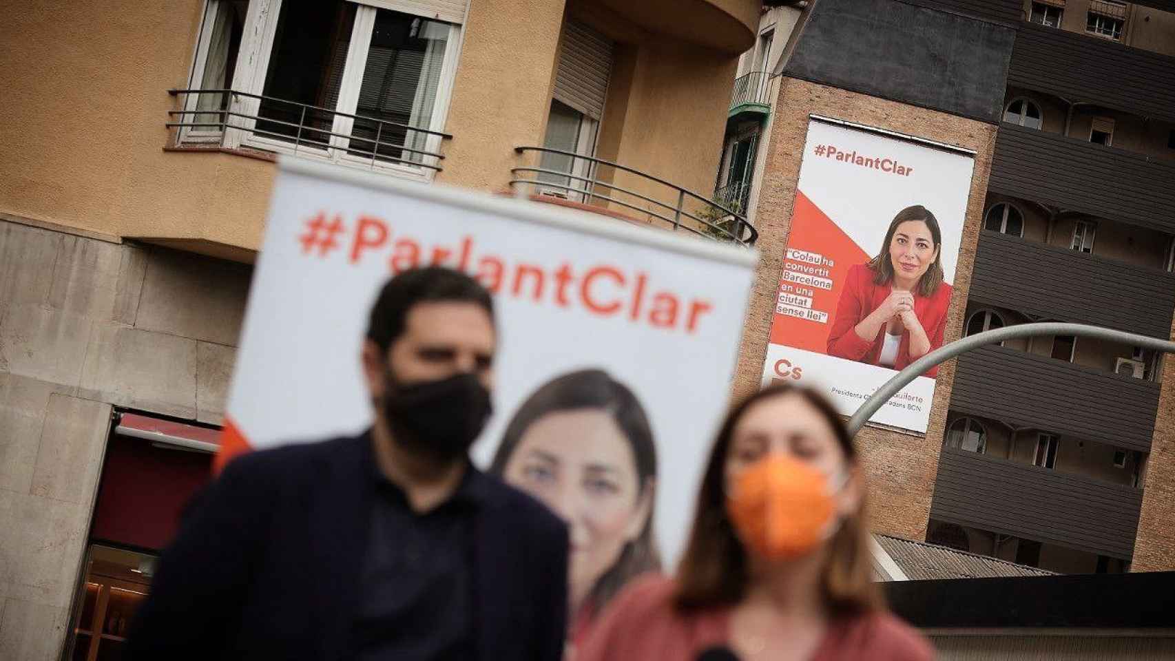 Los ediles Mariluz Guilarte y Paco Sierra, con un cartel de una campaña de fondo / CIUTADANS