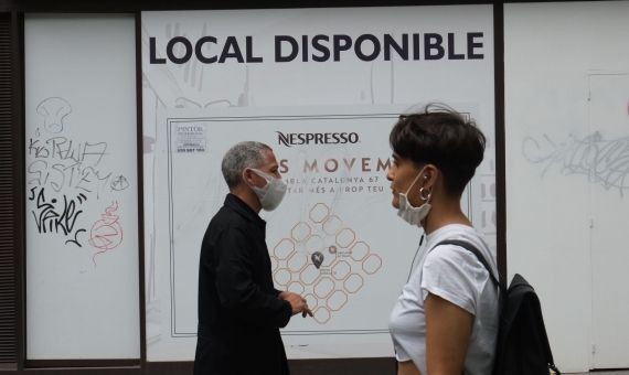 Personas pasan por delante de la antigua tienda de Nespresso, una de las firmas que ha abandonado el paseo de Gràcia / PABLO MIRANZO