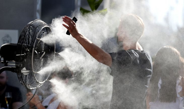 Un hombre se refresca con los ventiladores de una terraza debido a las altas temperaturas registradas en España - EFE / Zipi