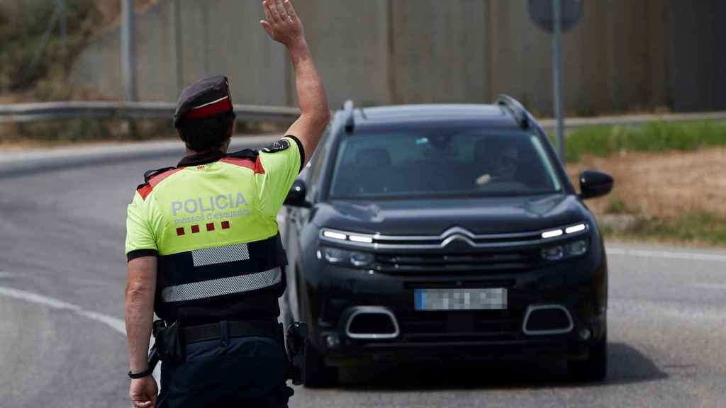 Un agente de los Mossos d'Esquadra da el alto a un conductor / EFE