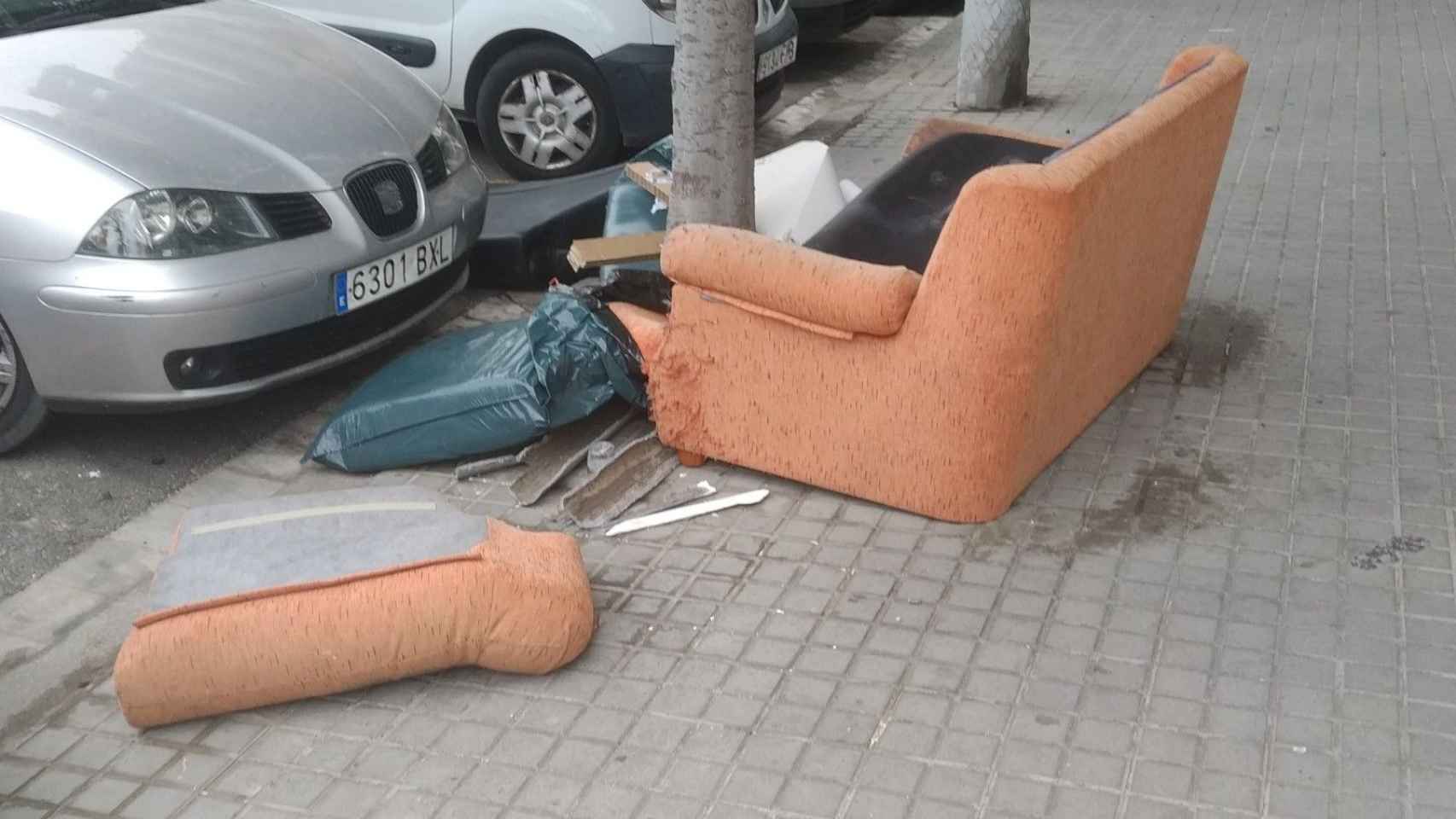 El sofá y la tubería rota en la esquina de Còrsega con Sant Quintí / METRÓPOLI - JORDI SUBIRANA