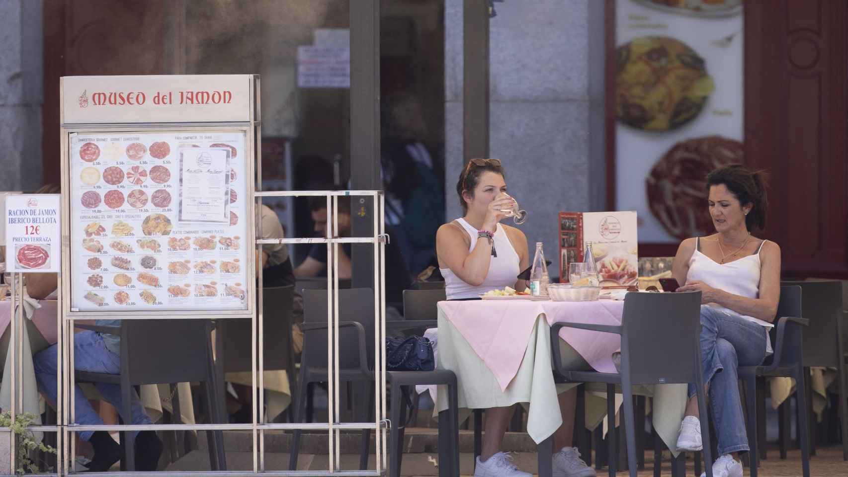 Dos personas en la terraza de un bar en una imagen de archivo