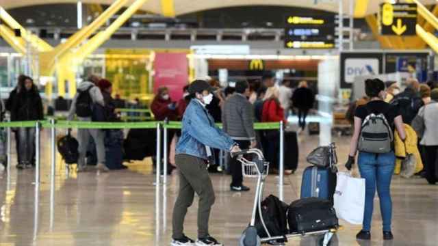 Pasajeros en un aeropuerto con mascarilla por el coronavirus / EFE