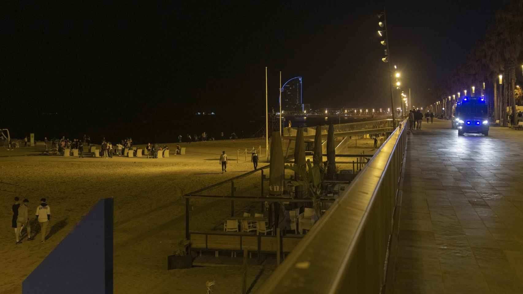 Un coche de policía vigila la playa de la Barceloneta durante el primer viernes sin toque de queda, a 14 de mayo de 2021, en Barcelona / EUROPA PRESS -