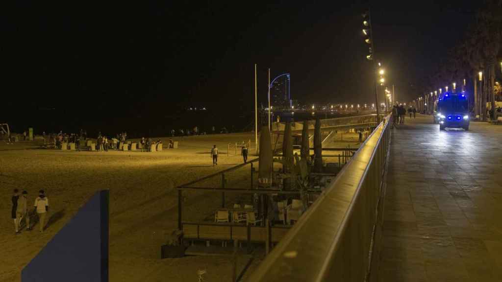 Un coche de policía vigila la playa de la Barceloneta durante el primer viernes sin toque de queda, a 14 de mayo de 2021, en Barcelona / EUROPA PRESS -