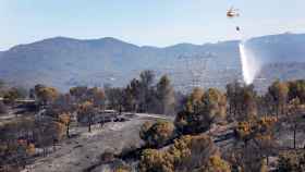 Un hidroavión trabaja cerca de la urbanización de Can Sunyer. El incendio que afecta a los términos de Castellví de Rosanes y Martorell, en Barcelona, continúa activo tras calcinar unas