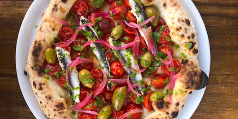 Pizza 'Boquerones' de La Balmesina, con tomates cherry, boquerones, cebolla encurtida, aceitunas, pesto de alcaparras y perejil / CEDIDA