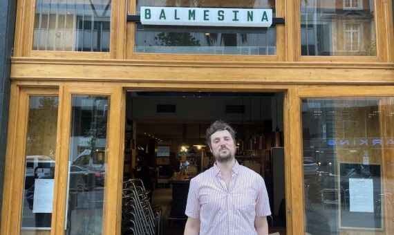 Massimo, uno de los tres socios de La Balmesina, en la fachada de la pizzería / METRÓPOLI