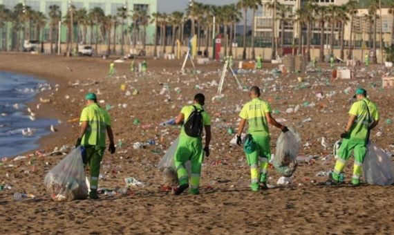 Empleados de Urbaser recogen la basura acumulada en la playa de la Barceloneta tras un botellón / ARCHIVO 