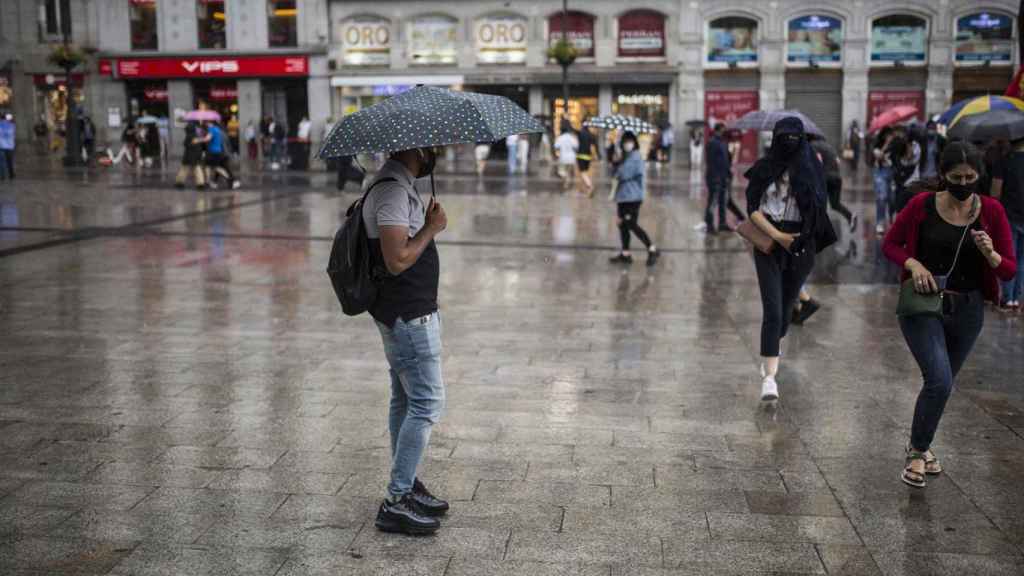 Ciudadanos resguardándose de la lluvia durante una manifestación en Madrid / Alejandro Martínez Vélez - Europa Press