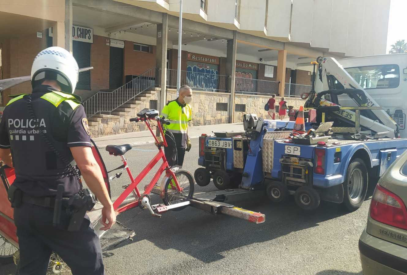 Una grúa municipal se lleva un bicitaxi ante un agente de la Guardia Urbana / TWITTER GUARDIA URBANA