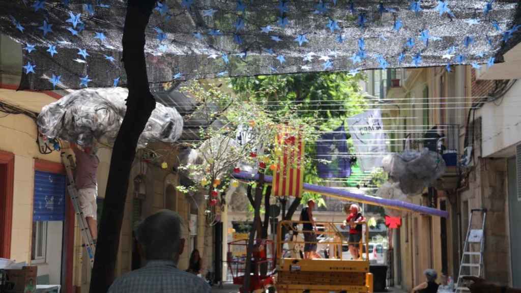 Montaje de la decoración de una calle de la Vil·la de Gràcia este viernes / JORDI CUIXART