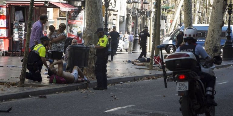 Agentes policiales junto a víctimas del 17A / EFE