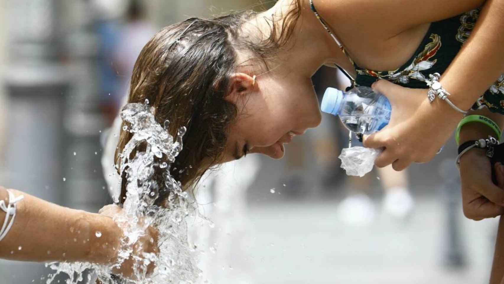 Una joven se remoja el pelo durante la ola de calor