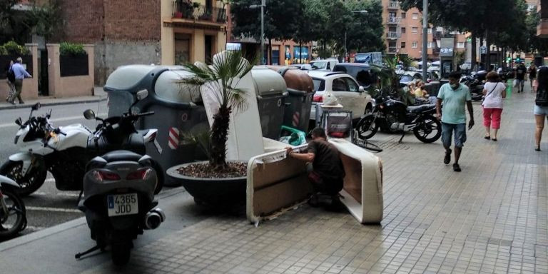 Un hombre manipula un colchón en el paseo de Maragall / METRÓPOLI