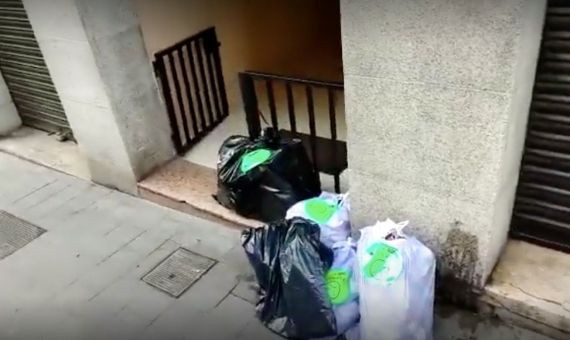 Bolsas de basura para recoger en un portal de Sarrià / METRÓPOLI - JORDI SUBIRANA