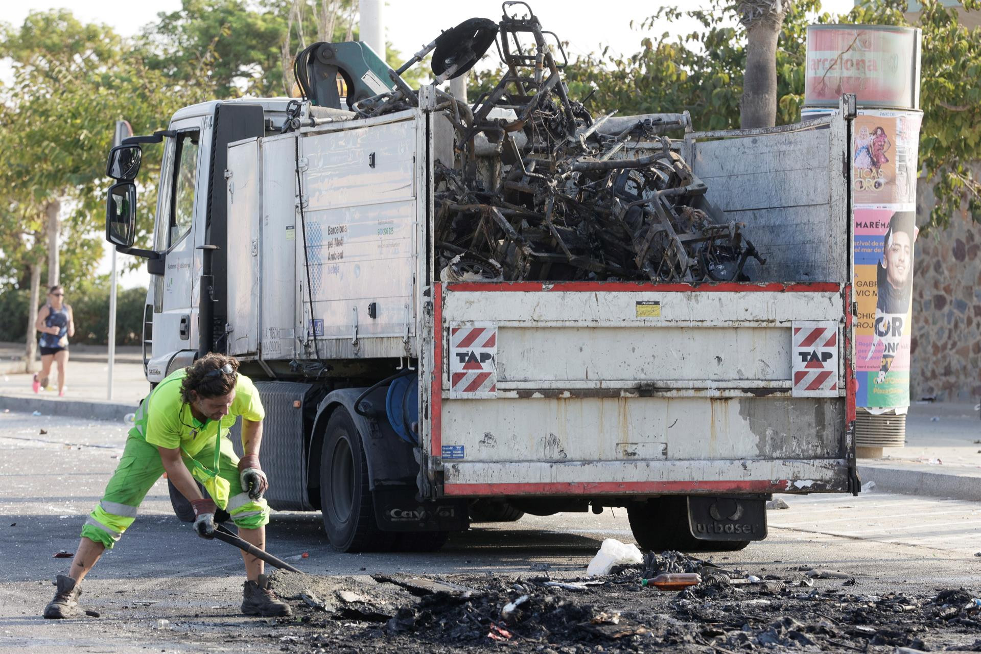  El servicio de limpieza recoge restos de motos calcinadas durante el tercer macrobotellón de la Mercè / EFE