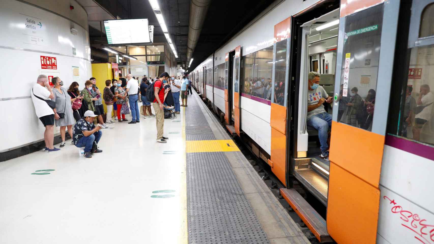 Varios pasajeros esperan ante un tren parado en la estación de Sants durante la huelga de maquinistas / EFE / Alejandro García