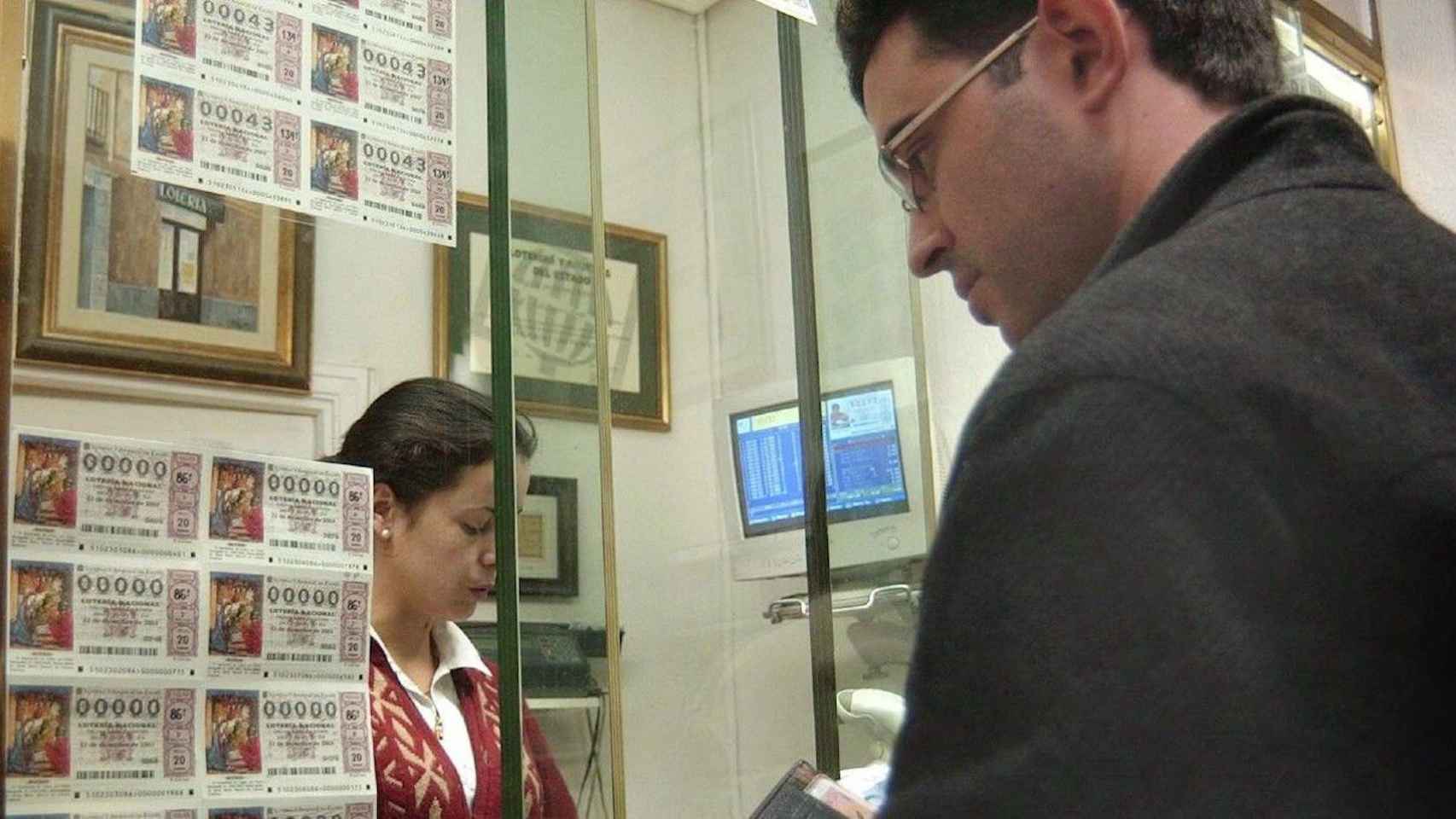 Persona comprando lotería en una administración / EFE