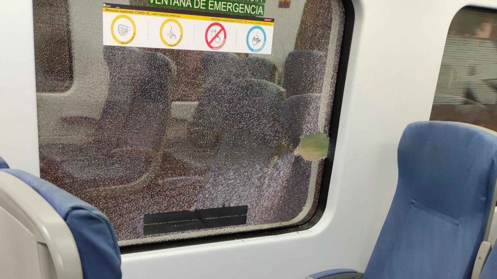 Ventana de un tren de Rodalies, rota por el impacto de una piedra que unos vándalos lanzaron contra un tren lleno de gente en Sant Adrià de Besòs en agosto